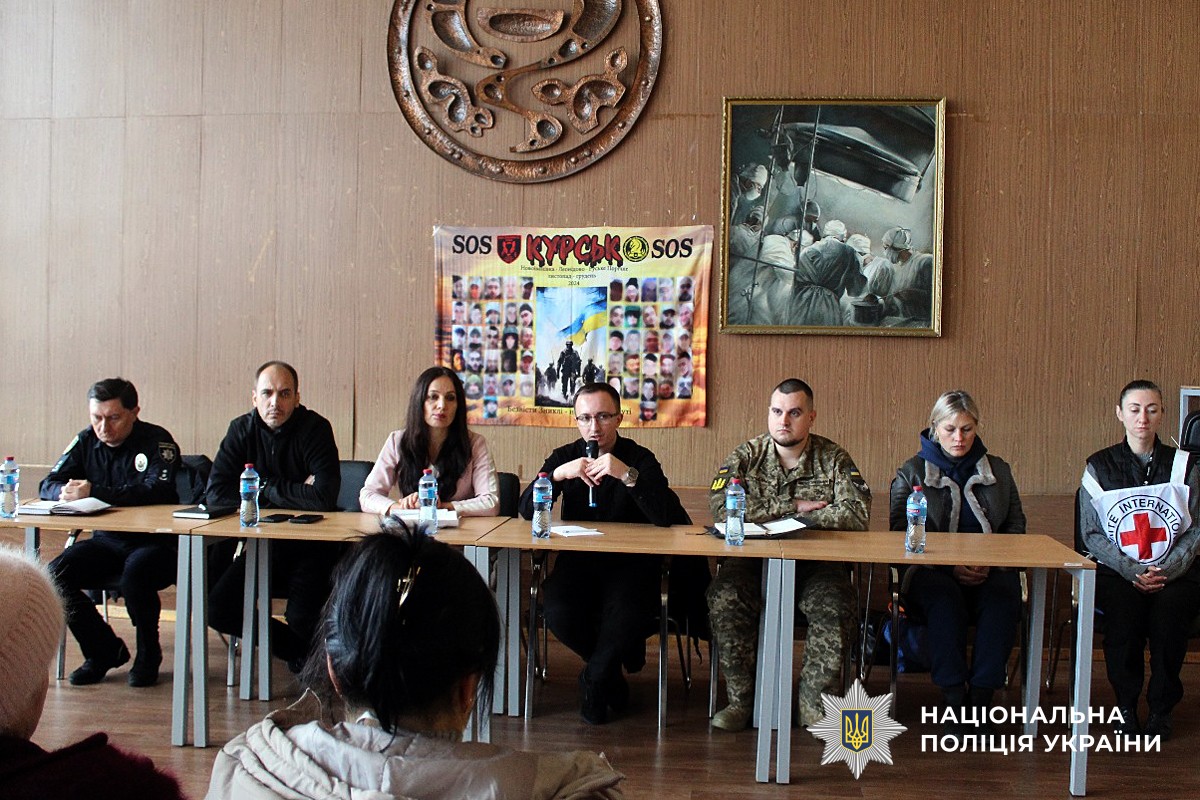 Слідчий поліції спілкСлідчий поліції спілкується з родинами під час зустрічі 