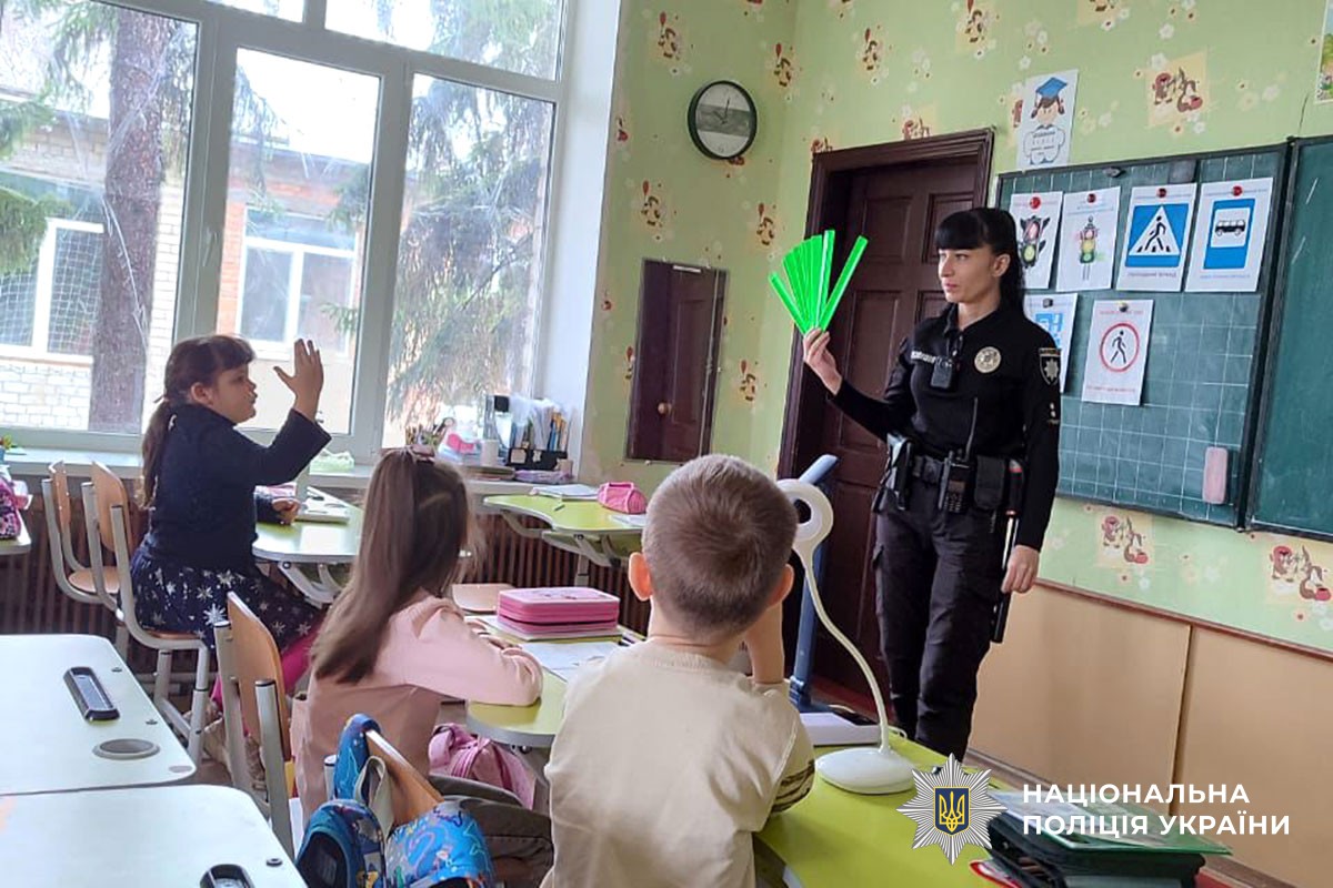 Поліцейська розповідає дітям про світловідбивачі 