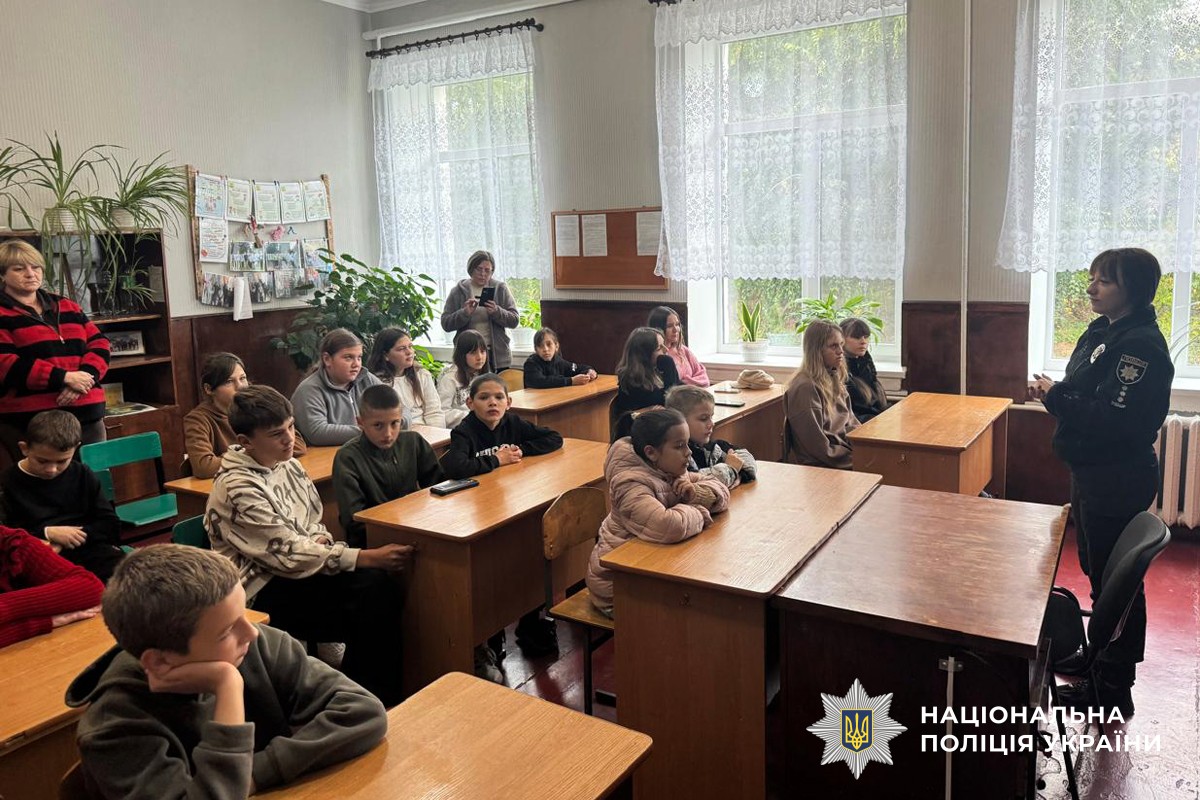 Поіцйескьа школярам у класі розповіда про правила безпеки