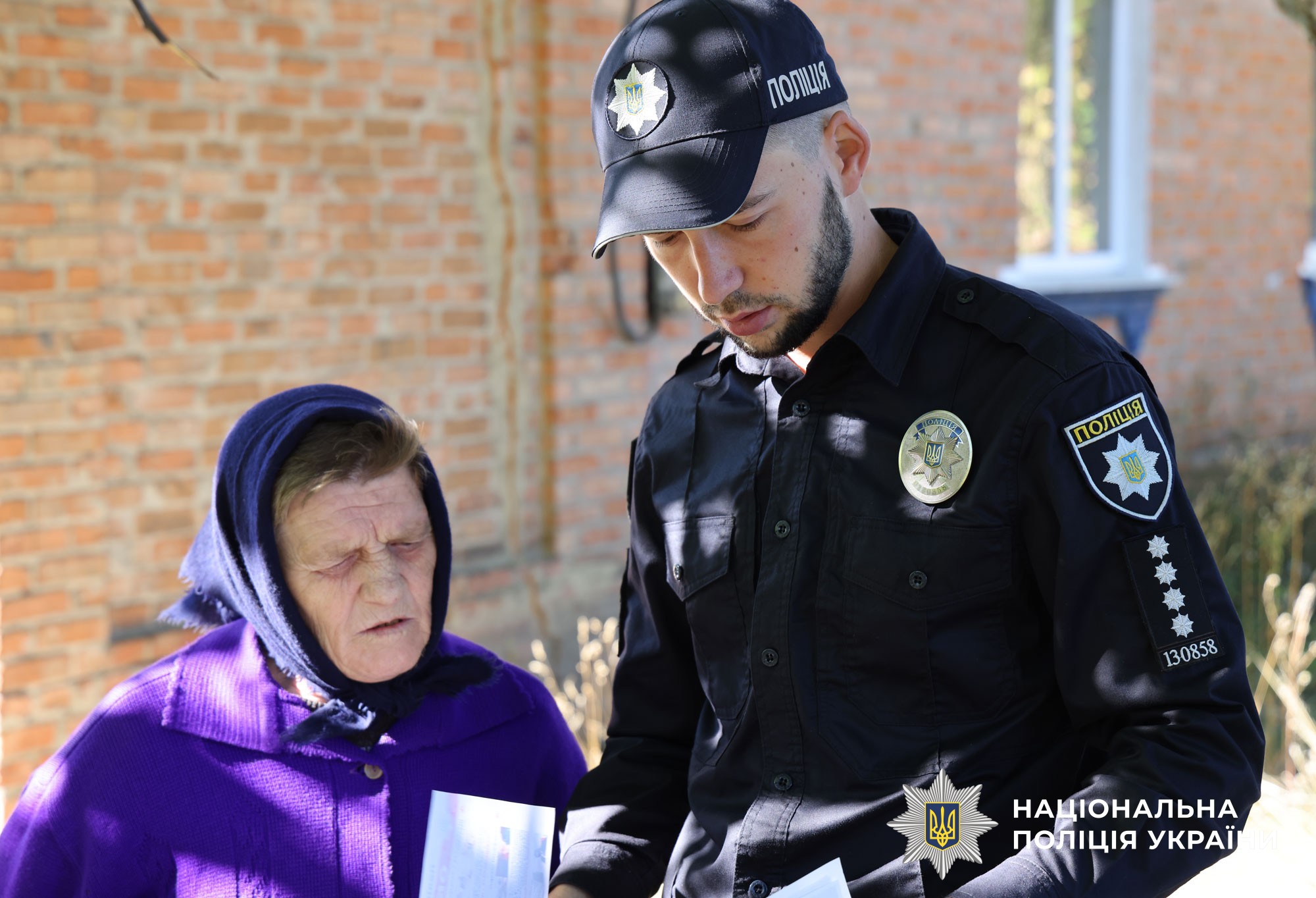 Поліцейський спілкується з жителями громади щодо шахрайств та радить як їх уникнути
