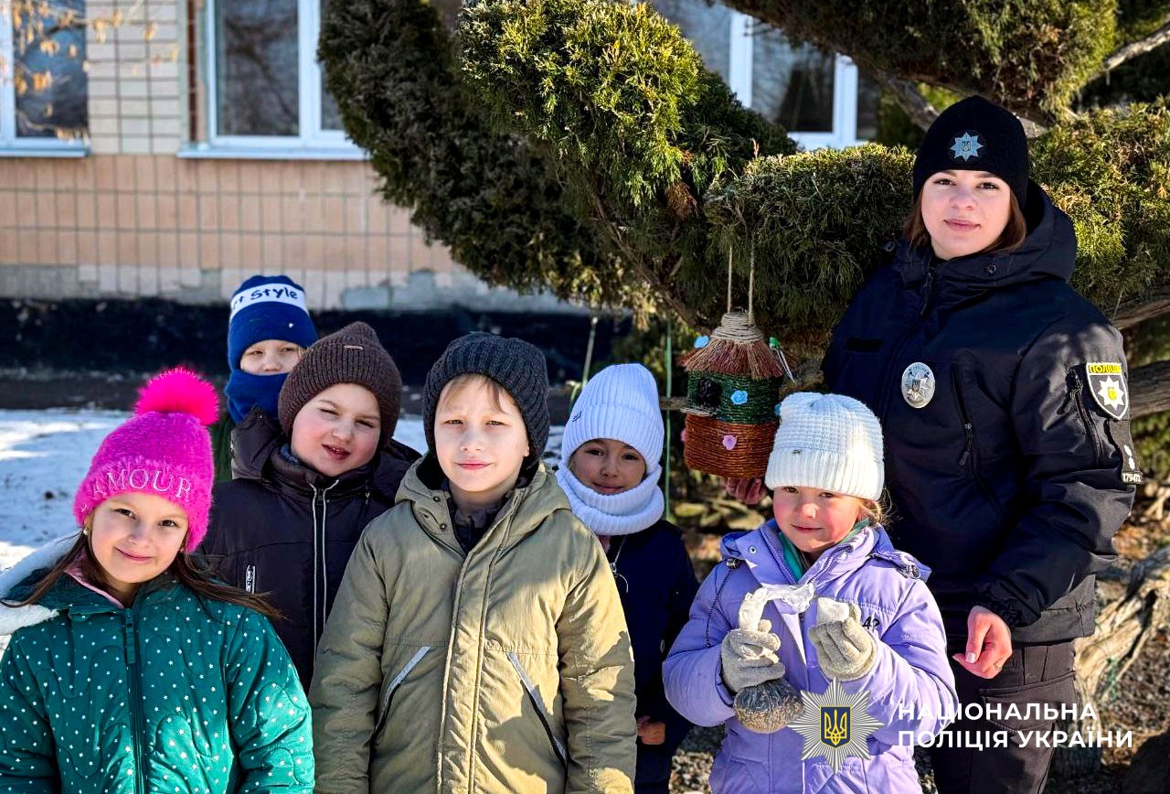 Поліцейські та діти підгодовують птахів узимку  