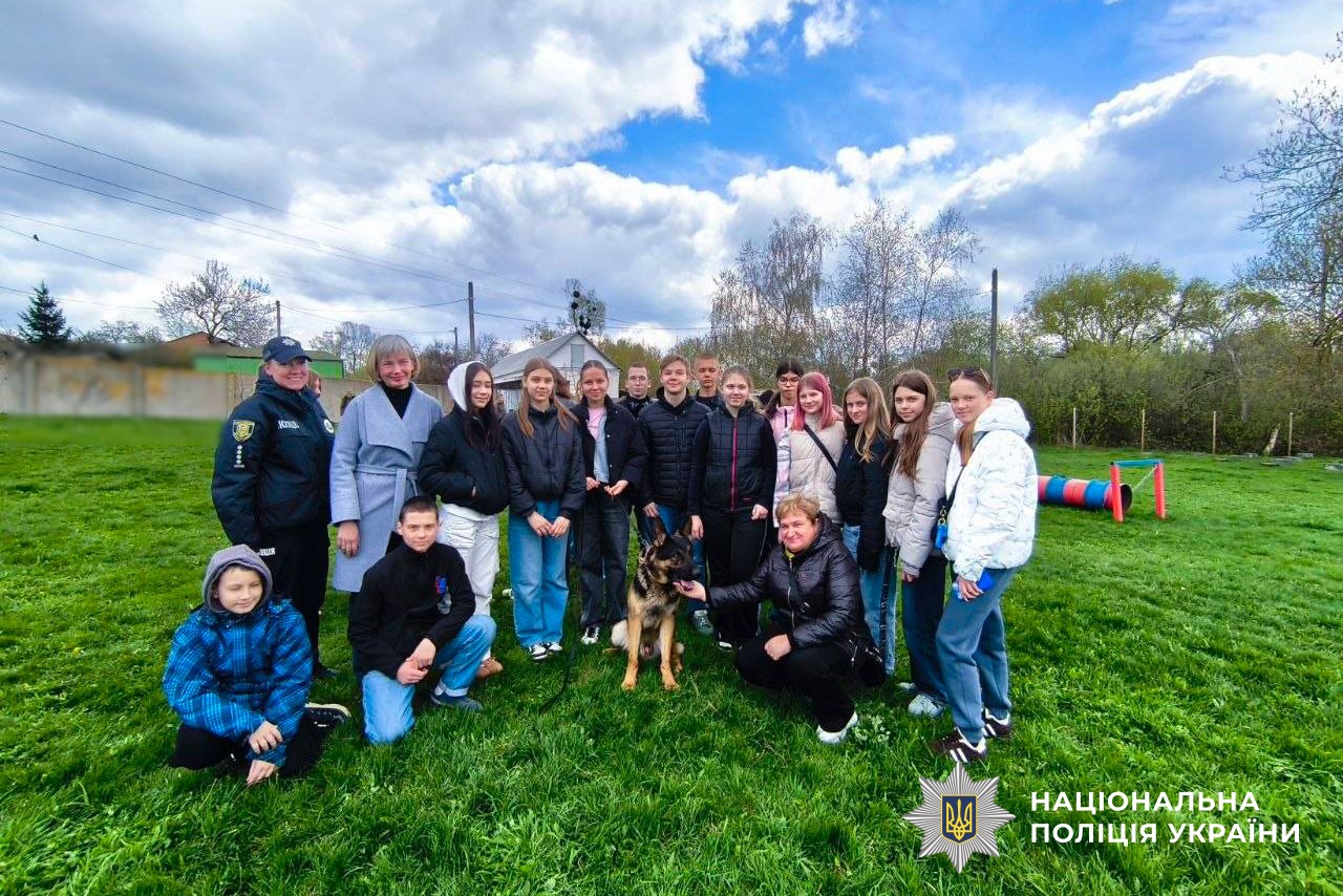 Діти дивляться на виступ службових собак