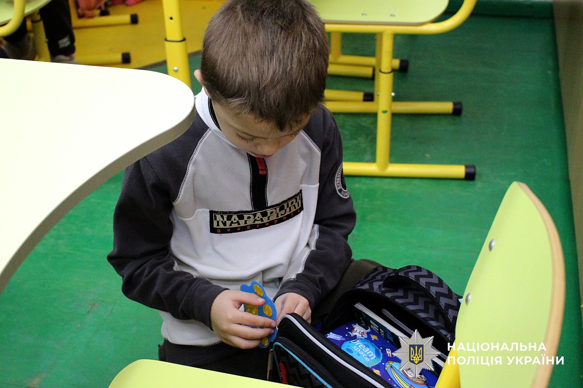 Хлопчик прикріпляє флікер на рюкзак