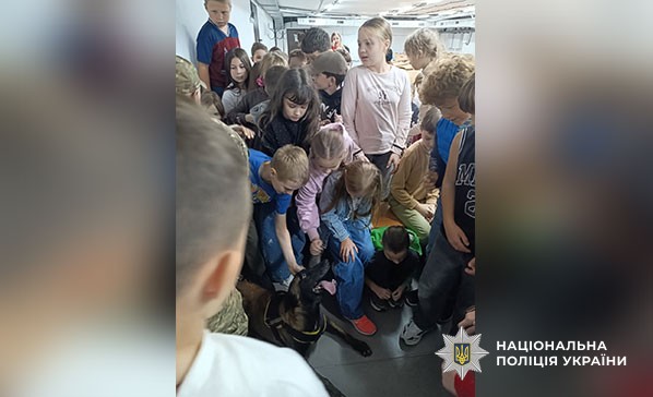 кінолог та собака показують дітям курс дресури