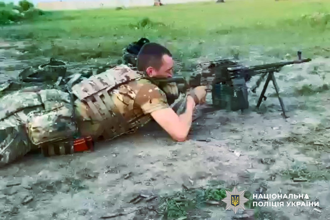 Тарас стріляє з кулемета лежачи