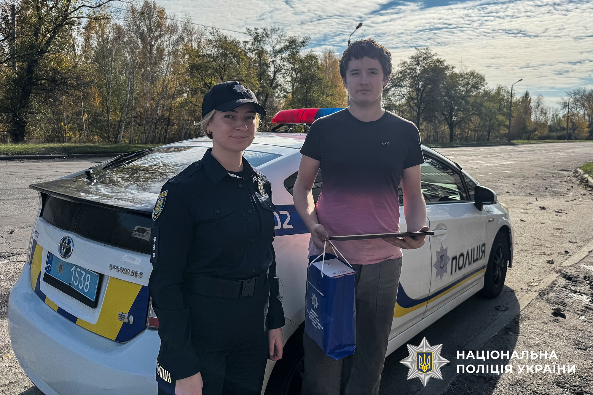 Поліцейська вручає подарунок та подяку