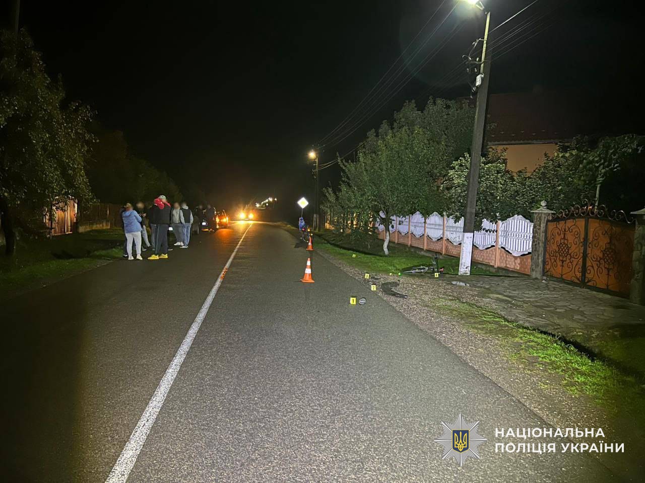 Вулиця населеного пункту вночі з мешканцями та конусами