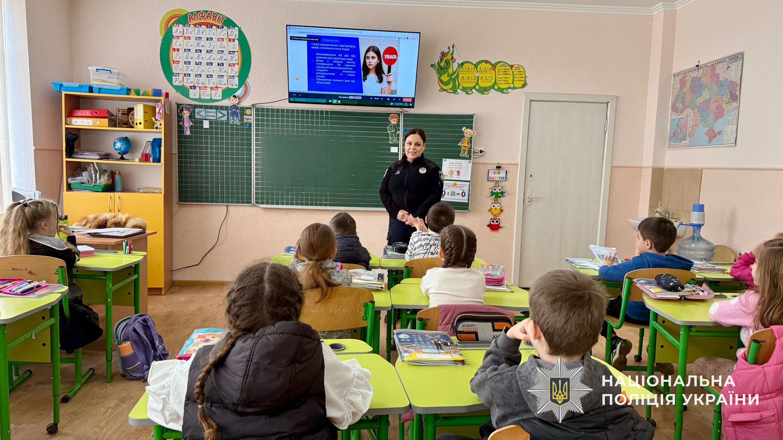 поліцейська перед класом розповідає дітям