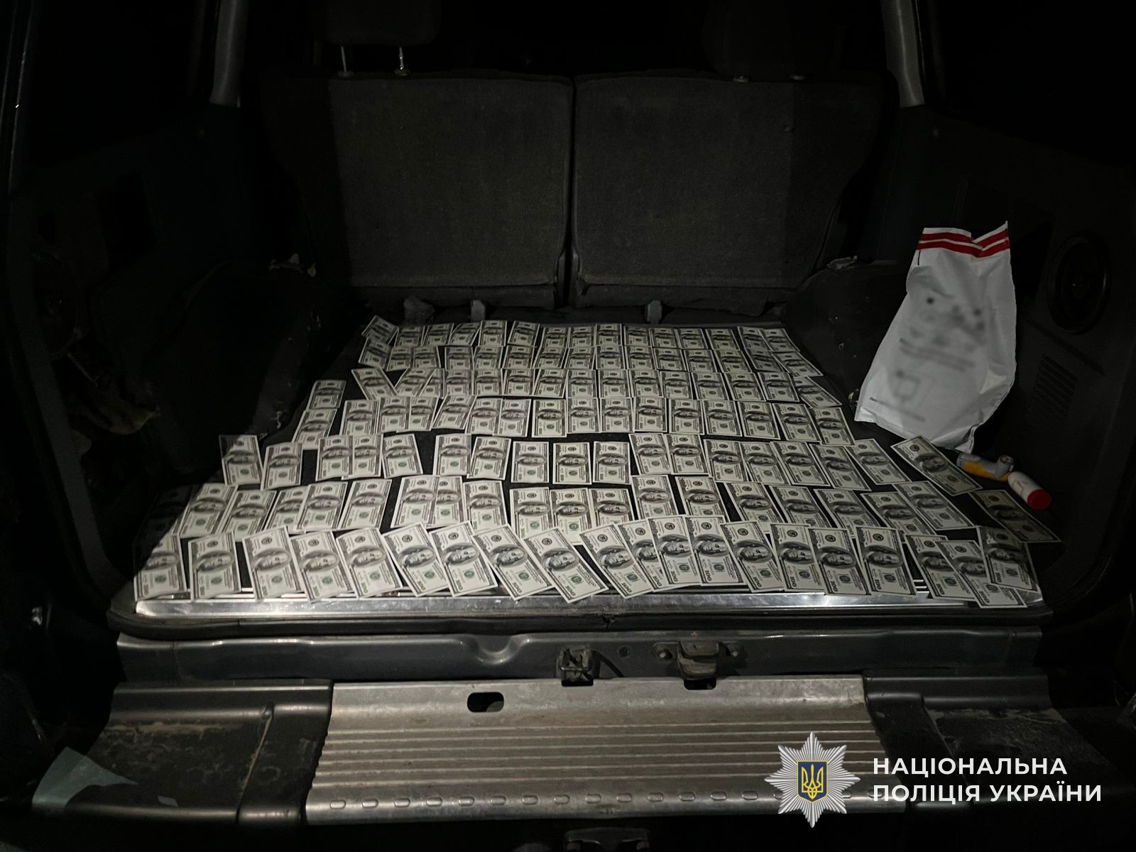 Багажник автомобіля фігуранта, заповнений розкладеними стодоларовими купюрами