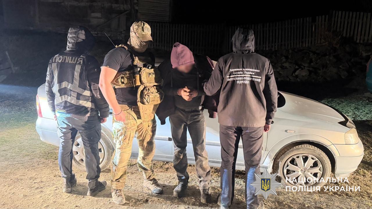 Правоохоронці тримають за руки мешканця села Чорна Тиса, підозрюваного в незаконному переправленні особи через кордон
