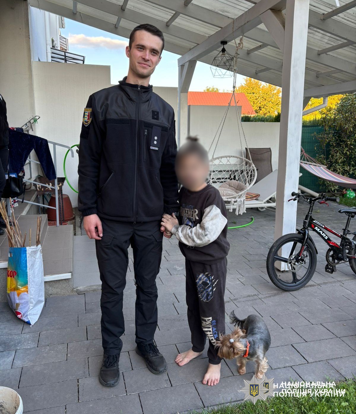 Поліцейський тримає за руку 10-річного хлопчика, якого розшукав неподалік залізниці у Минаї