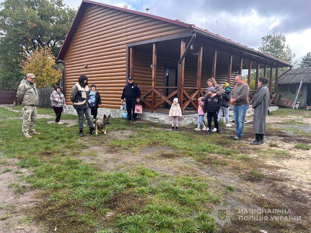 кінологи та службова вівчарка на подвір'ї з родиною