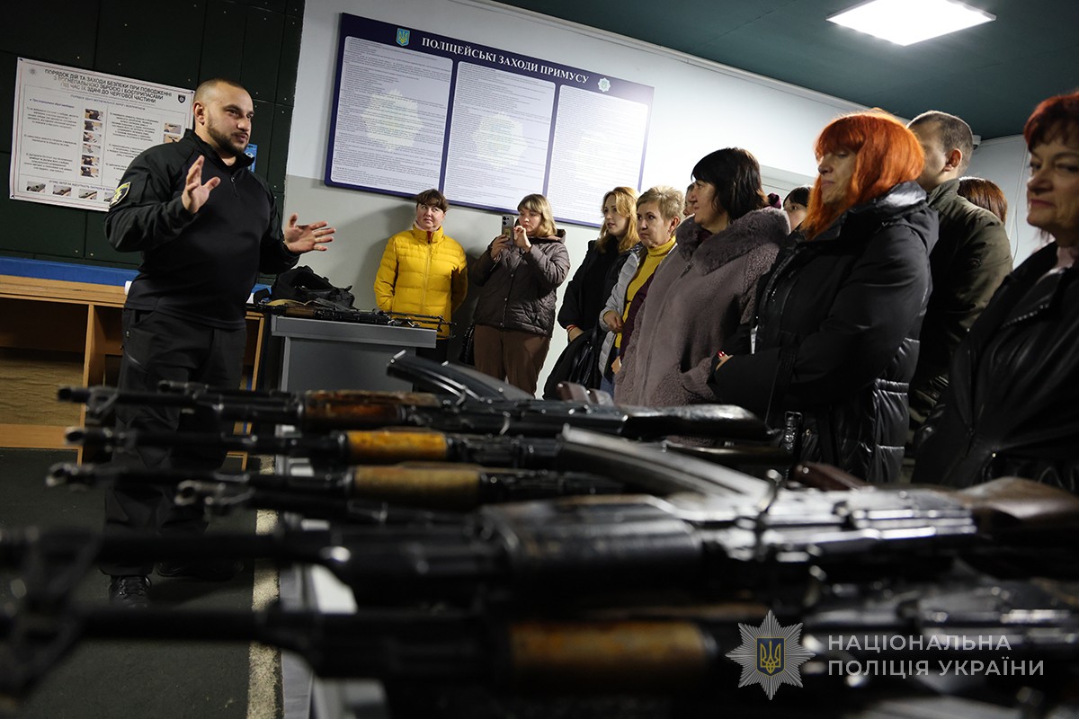 інструктор з вогневої підготовки спілкується з учасниками в тиру