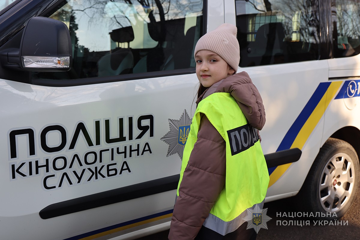 дівчинка на фоні службового авто