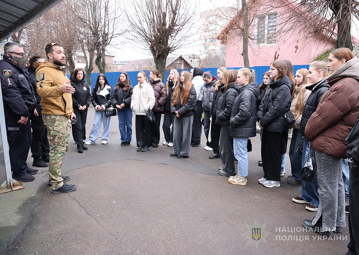 студенти слухають викладача академії на вулиці