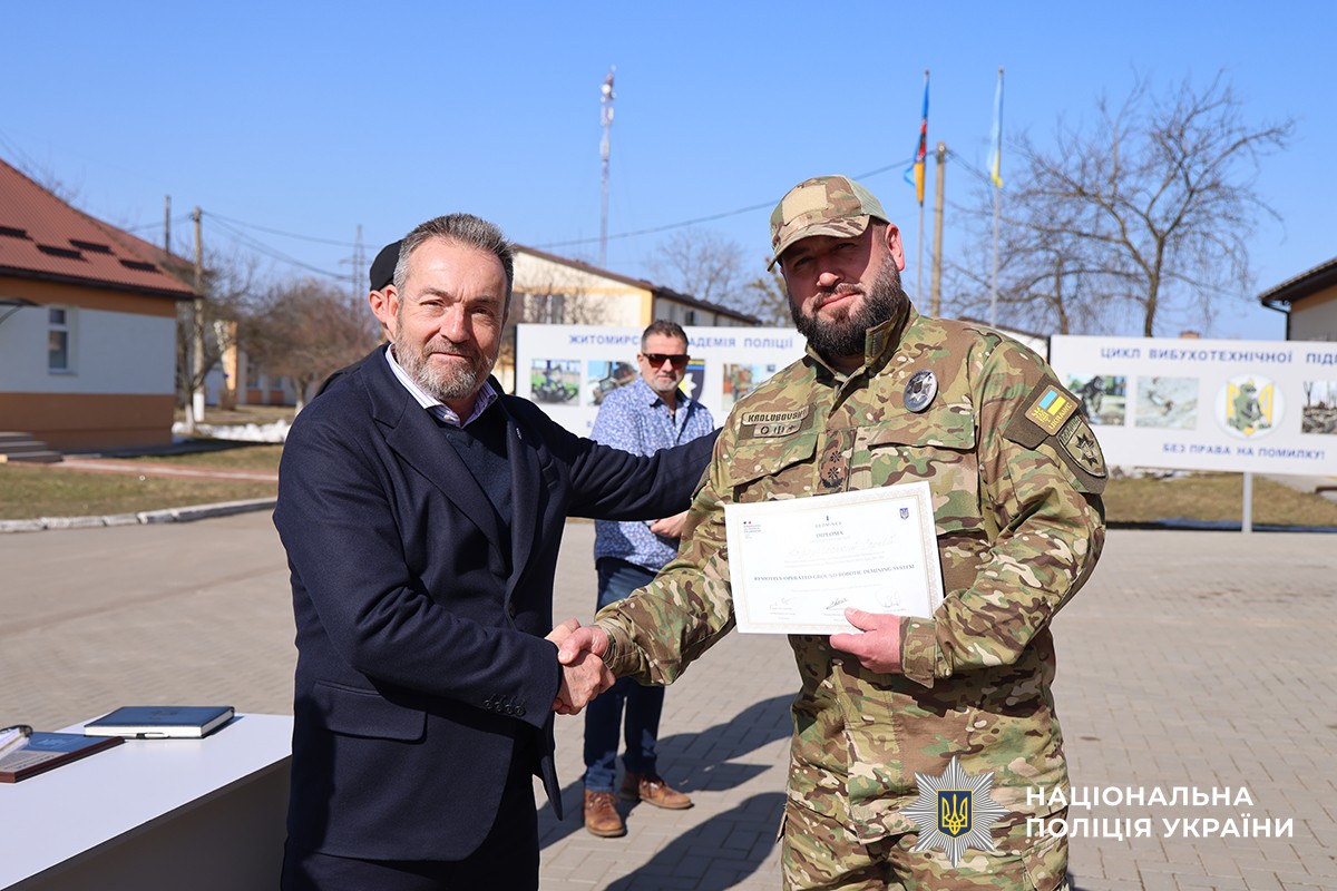 француз вручає сертифікат вибухотехніку