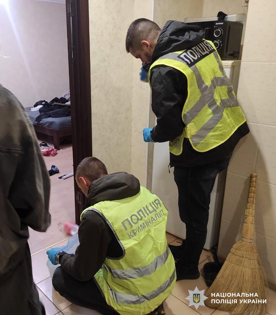 Двоє поліцейських проводять обшук в помешканні фігуранта