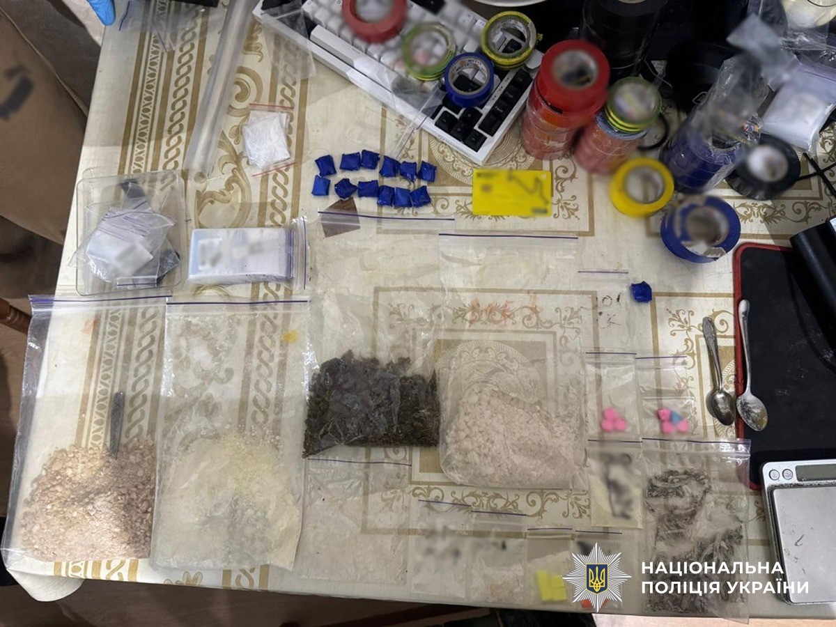 Вилучене лежить на столі: ізоляційні стрічки, понад 10 згортків з наркотичними речовинами, банківська картка, зіп-пакети із сухою рослинною масою та порошкоподібними речовинами