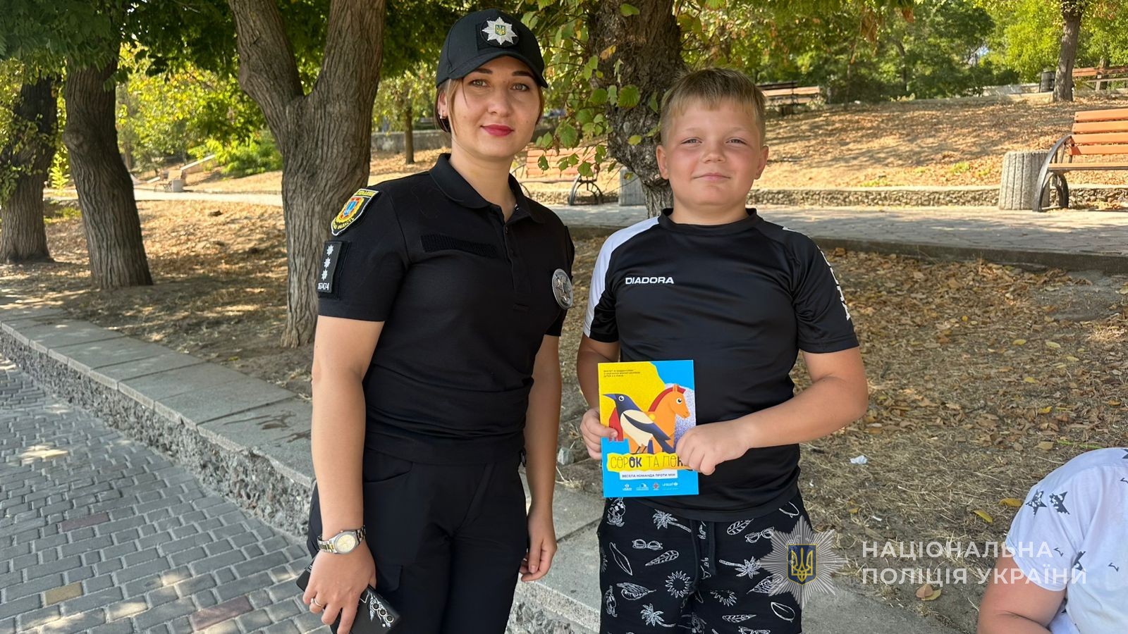 Поліцейська разом із хлопчиком фотографуються.
