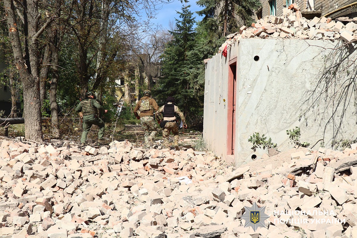 Поліцейські ідуть біля зруйнованої будівлі