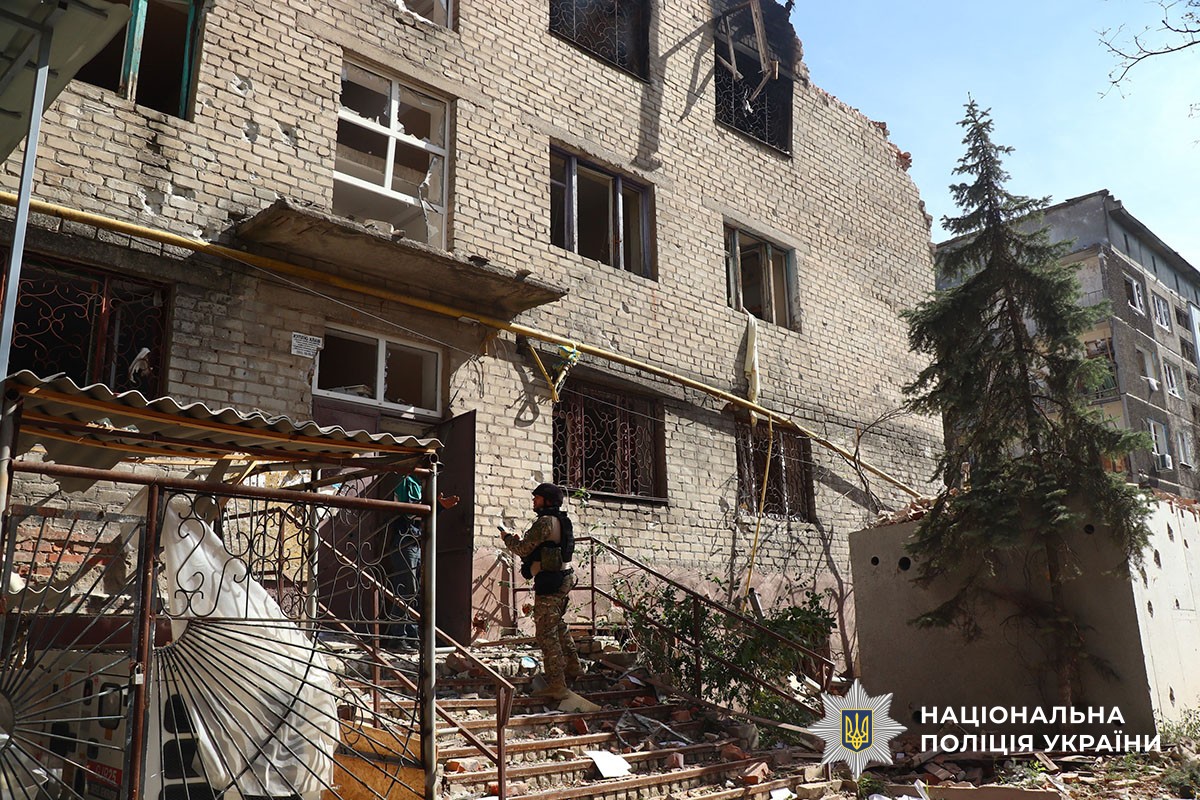 Поліцейський біля зруйнованої будівлі