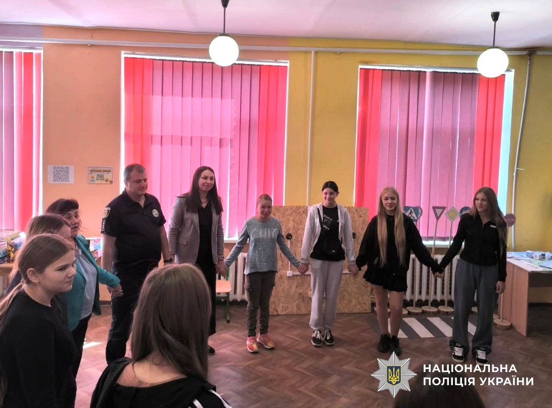 учні, поліцейський, представниця прокуратури разом стоять у колі