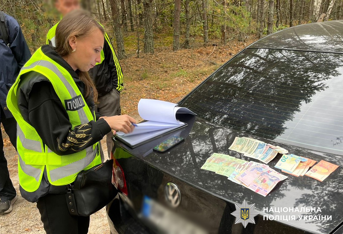 на капоті чорного авто лежать гроші, слідча документує