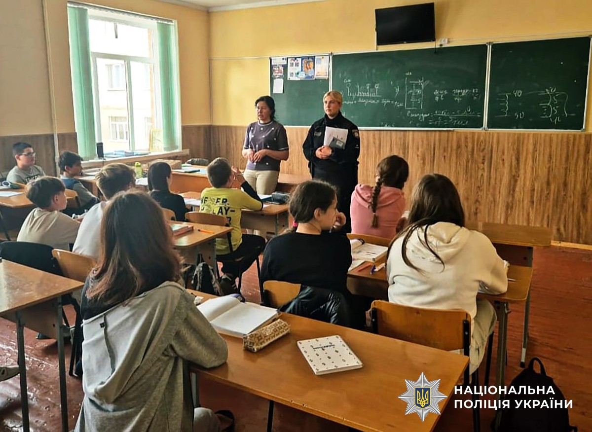 Поліцейська та вчителька щось розповідають учням-підліткам у класі