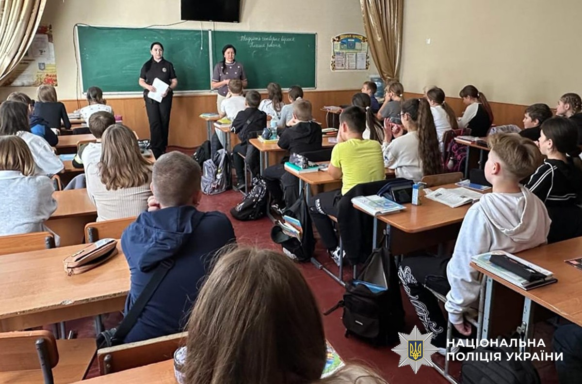Поліцейська та вчителька щось розповідають учням-підліткам у класі