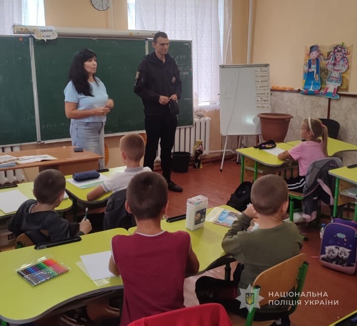 Поліцейський проводить учням профілактичний урок в класі.