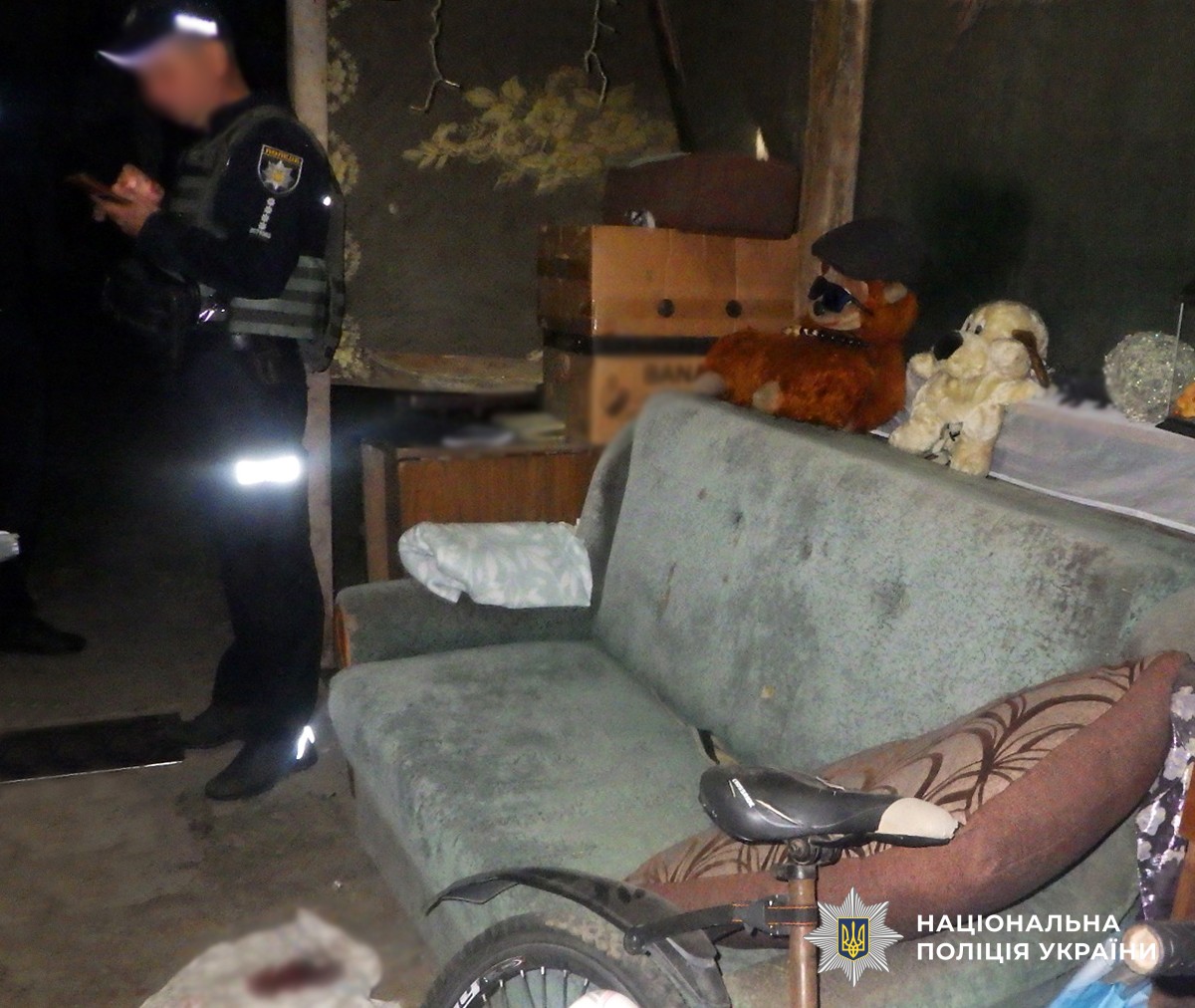 Приміщення, де стався злочин. Поліцейський документує. На підлозі ганчірка в крові.