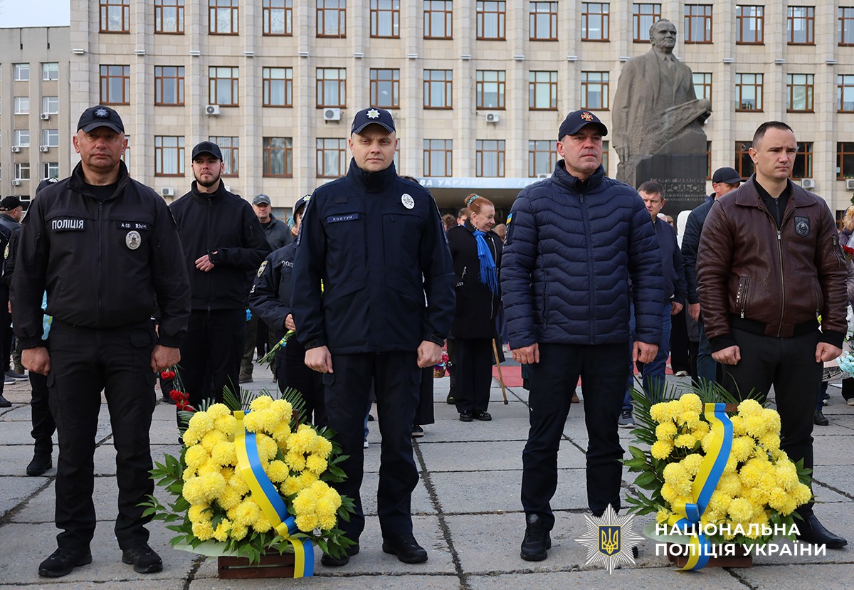 керівництво Поліції Житомирщини та ДСНС стоять. Поряд із ними жовті квіти у кошиках