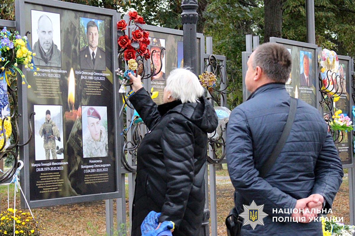 Рідні кладуть квіти до постаменту загиблого