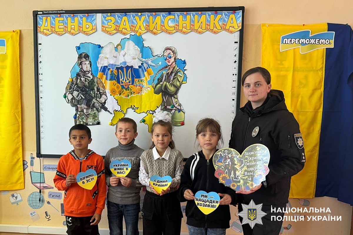 Фото поліцейської з дітьми, де вони демонструють своїми малюнки