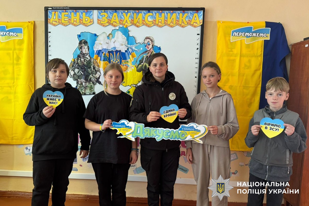 Фото поліцейської з дітьми, де вони демонструють своїми малюнки