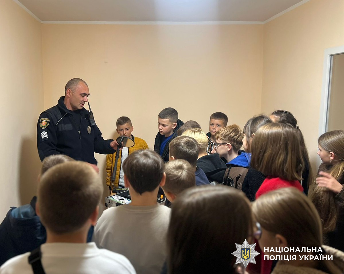 Поліцейський показує дітям спеціальні засоби поліцейського