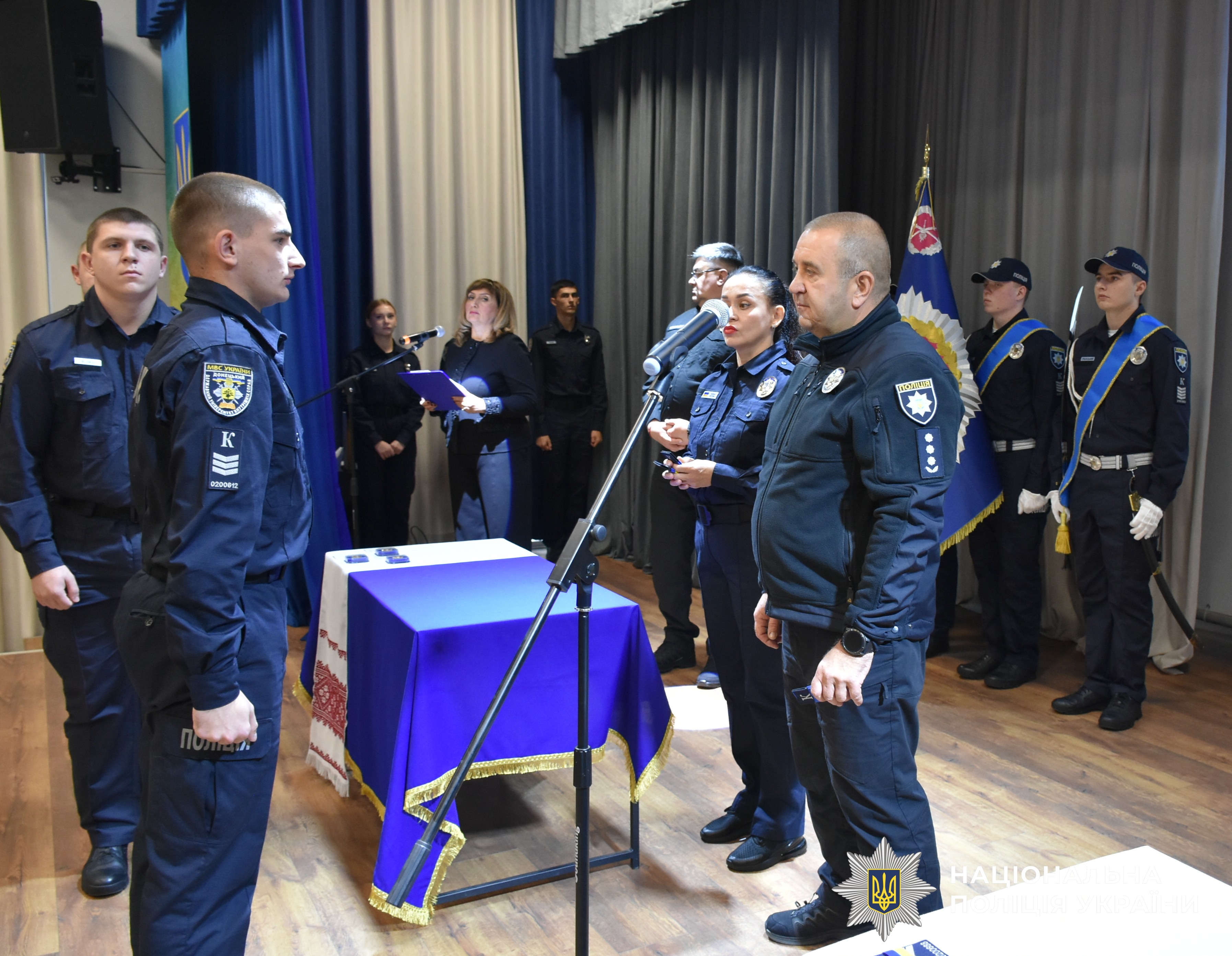 керівник поліції області вручає курсантку погони
