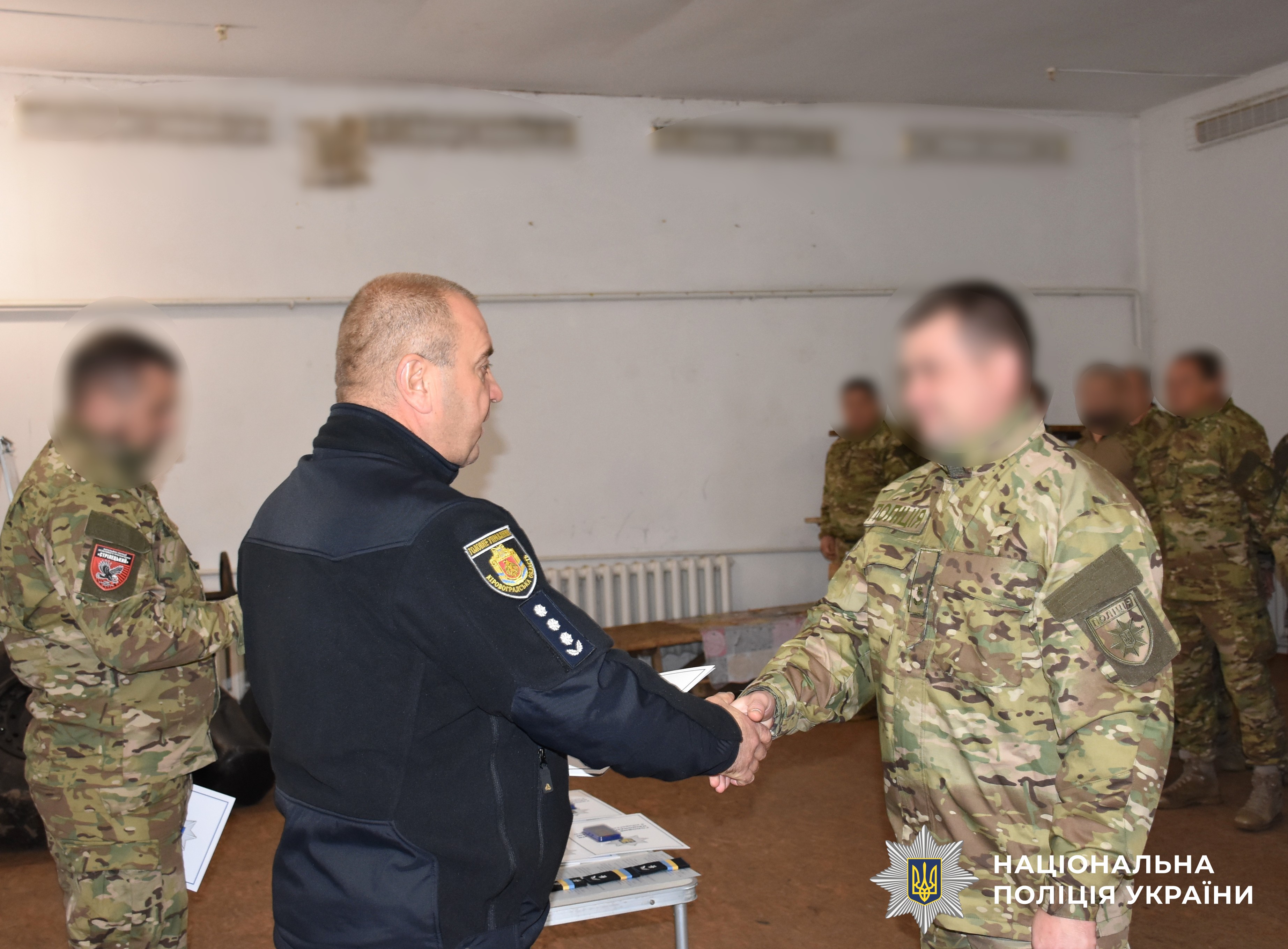 керівник поліції області вручає нагороду поліцейському