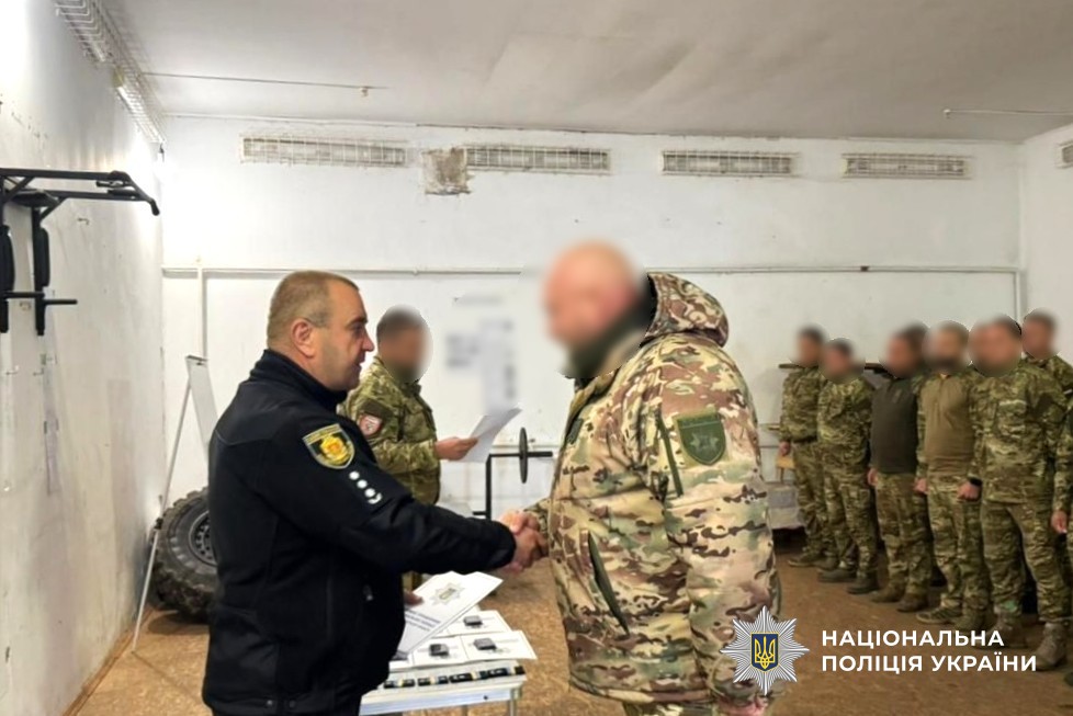 керівник поліції області вручає нагороду поліцейському