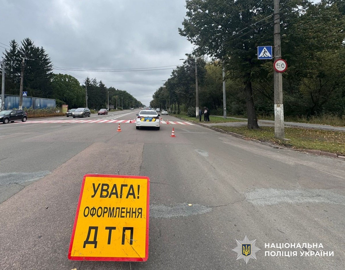 На дорозі стоїть таблиця про оформлення ДТП. Також стоїть поліцейський автомобіль.