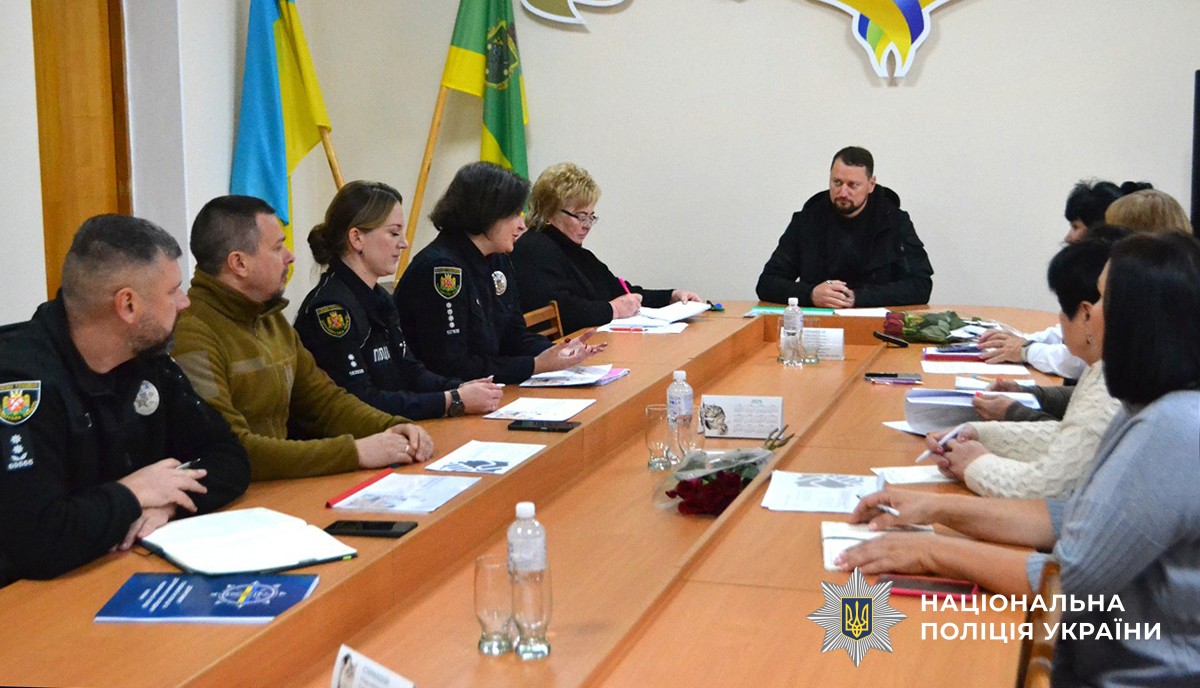 за столом сидять освітяни, управлінці ат поліцейські