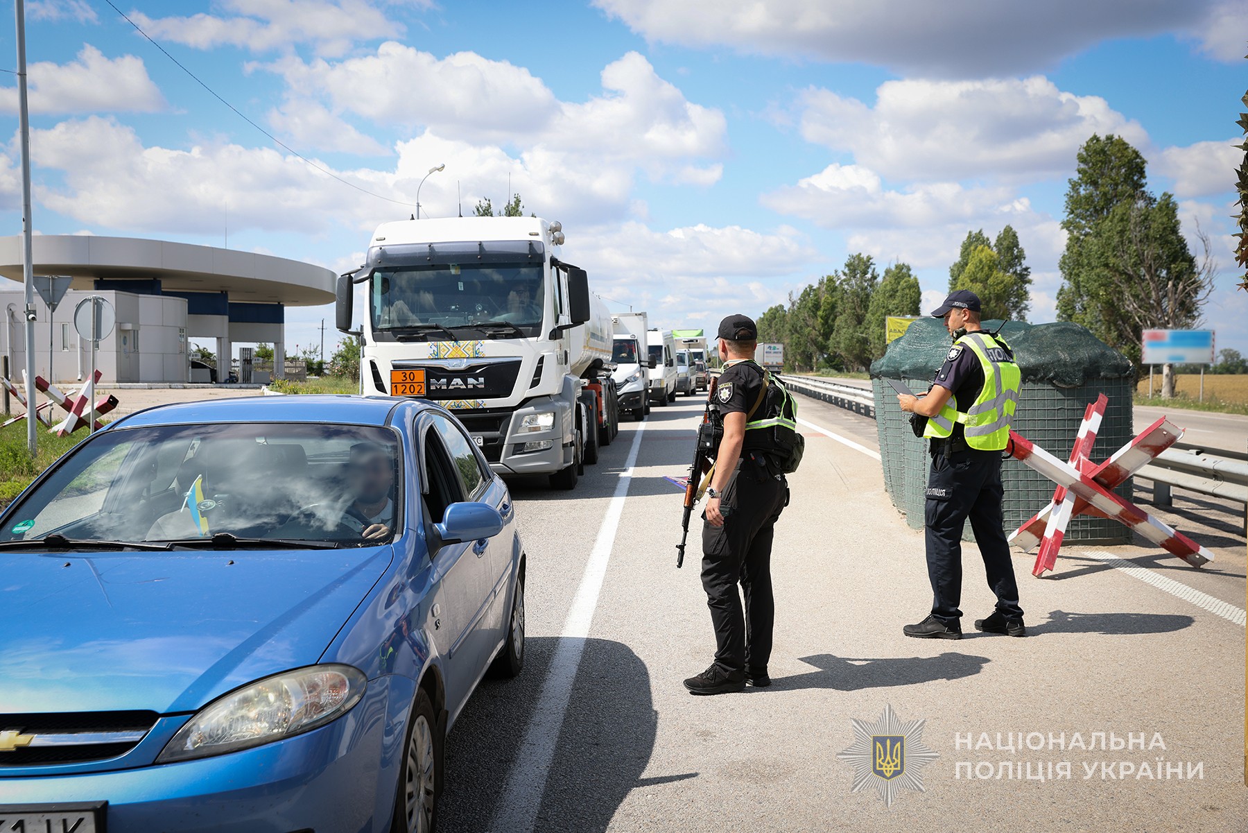 Поліцейські перевіряють транспортні засоби на блокпосту.