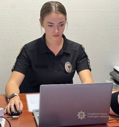 Поліцейська працює за робочим столом.