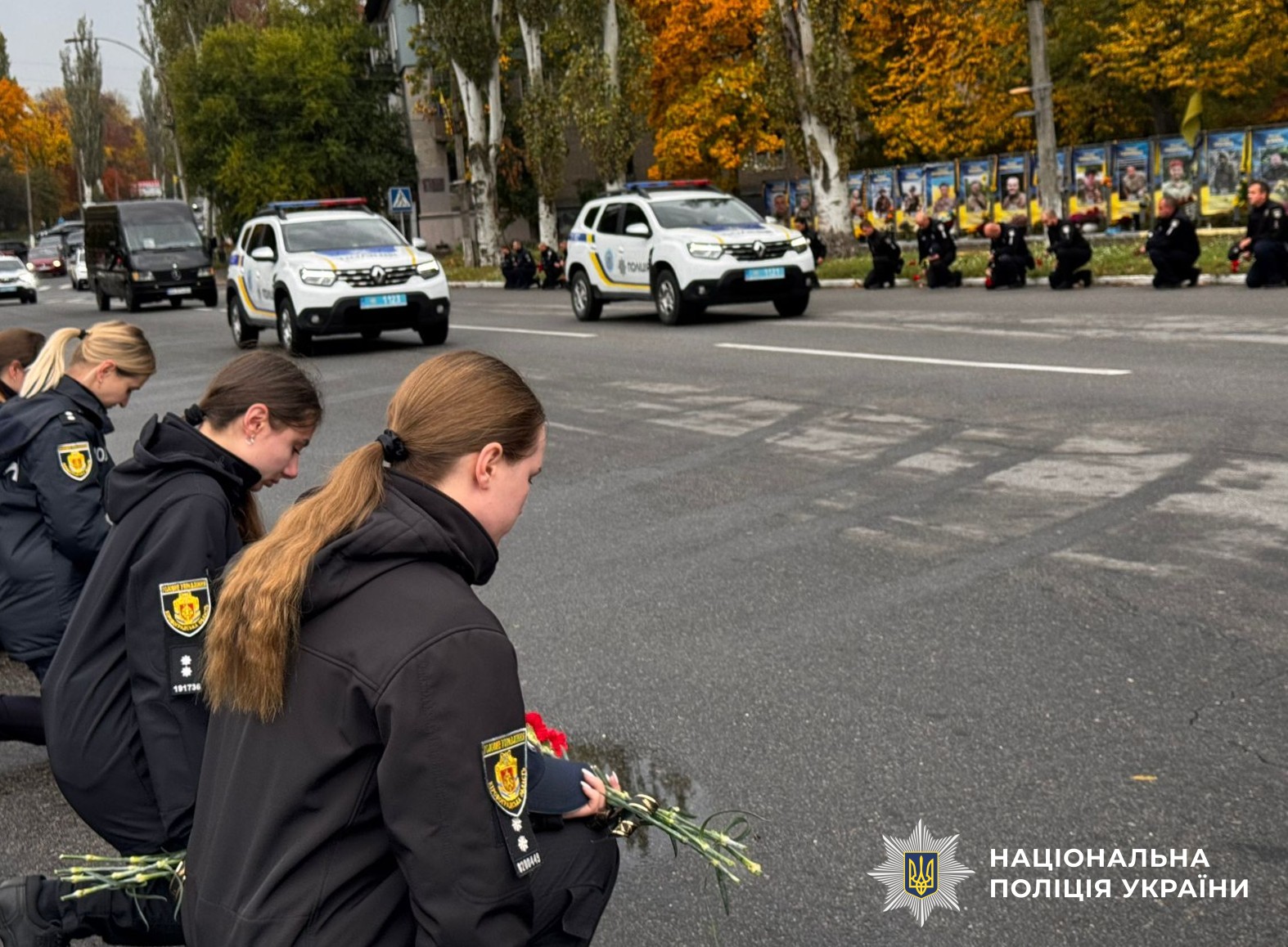 поліцейські стоять на коліні вздовж узбіччя, зустрічають траурний кортеж