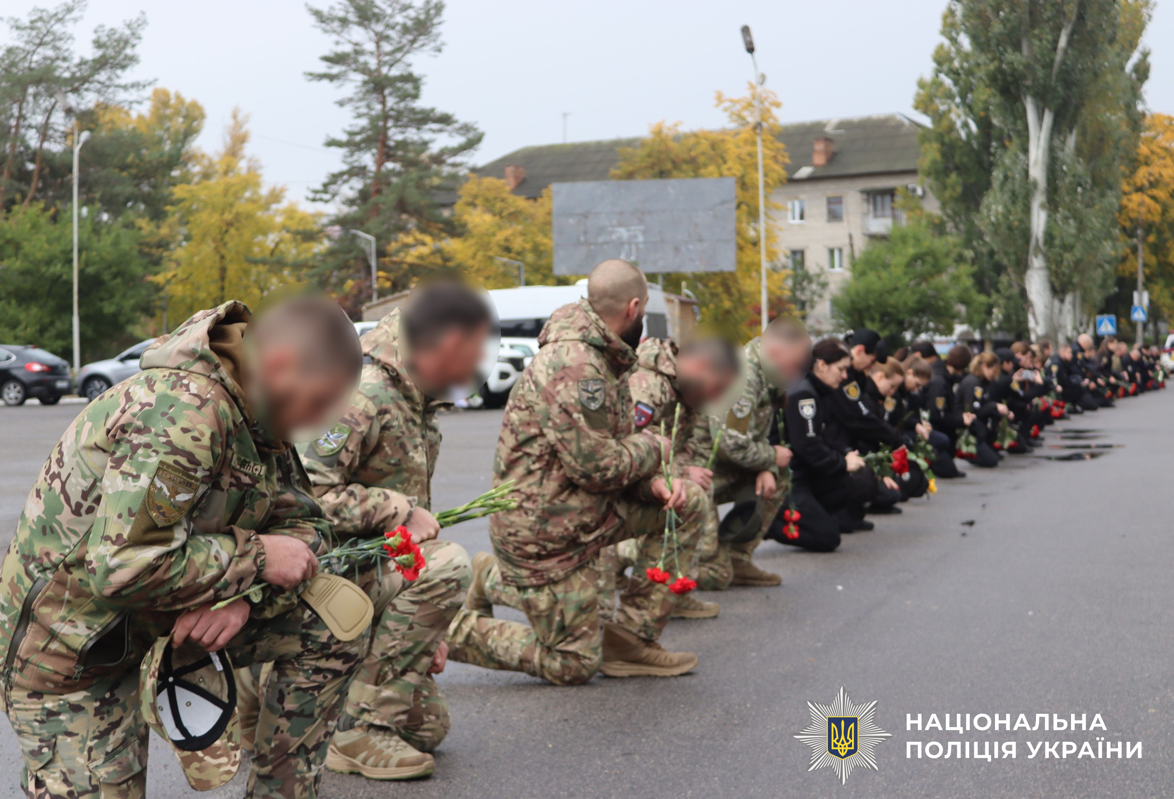 поліцейські стоять на коліні вздовж узбіччя, зустрічають траурний кортеж