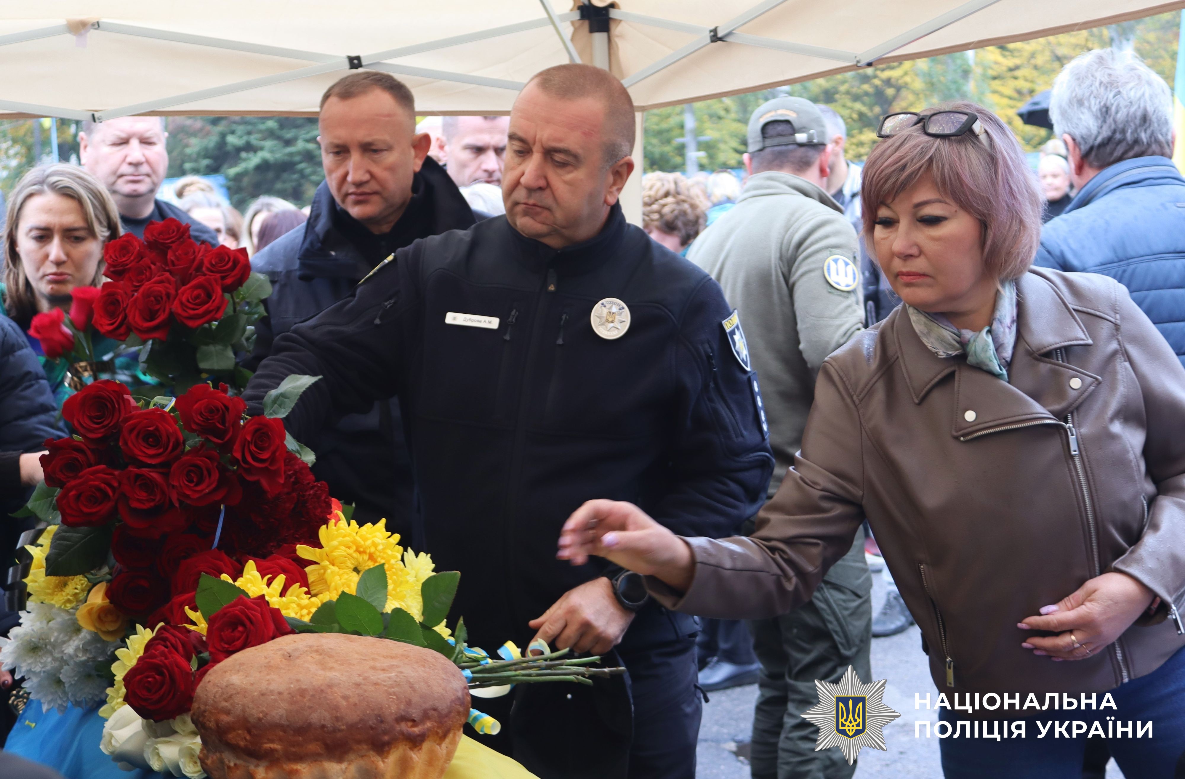 представники поліції, громадяни кладуть квіти на труну
