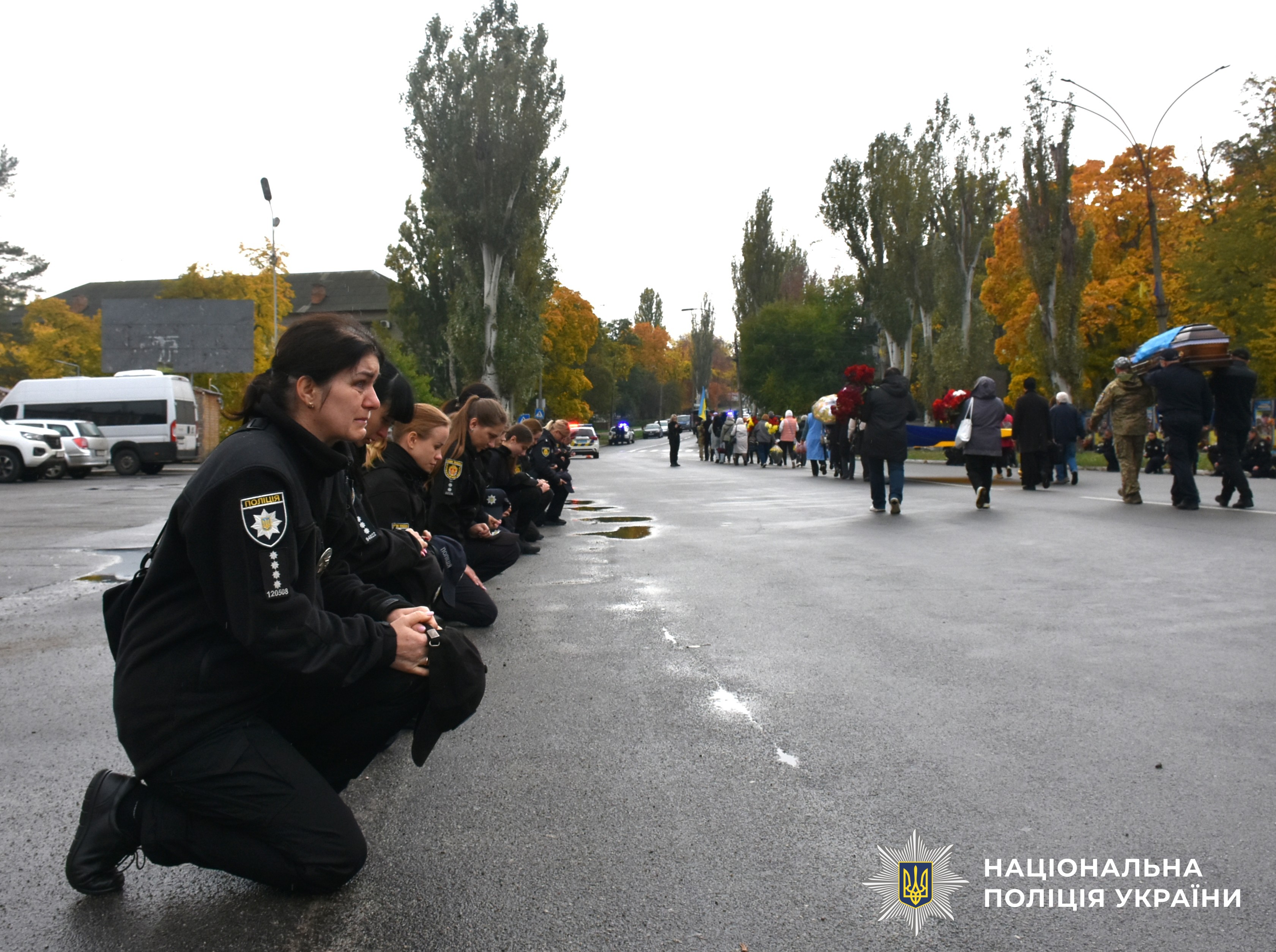 поліцейські стоять на коліні проводжаючи траурну процесію