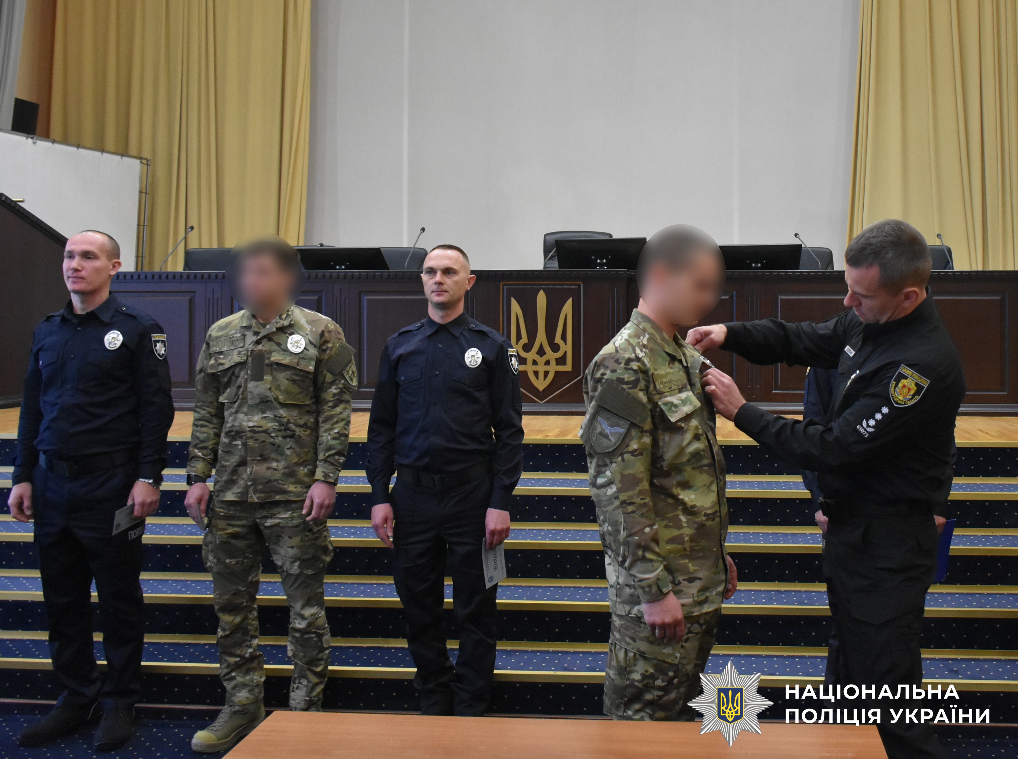 заступник керівника поліції області вручає жетон поліцейському