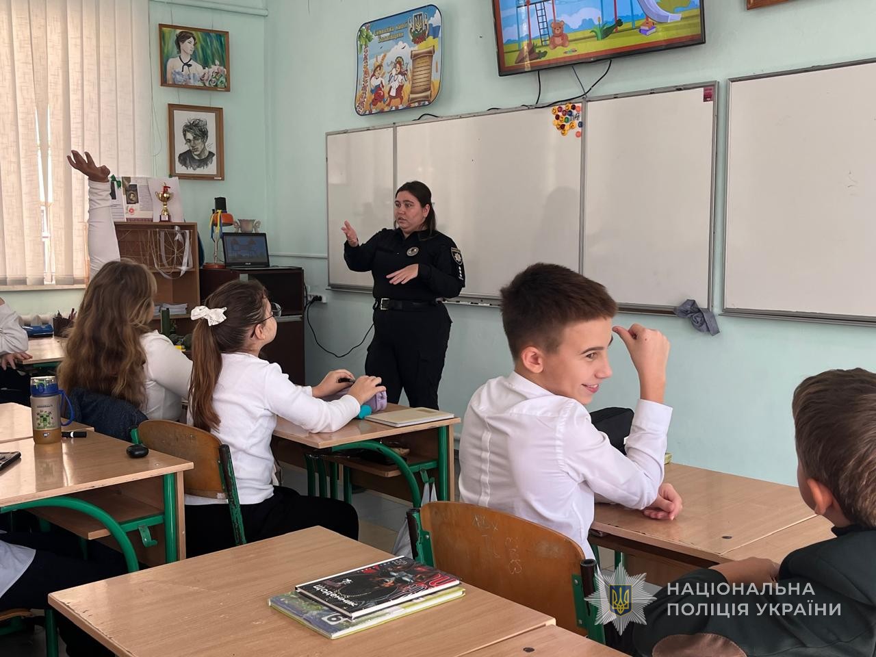 Поліцейська проводить діткам профілактичні заходи.