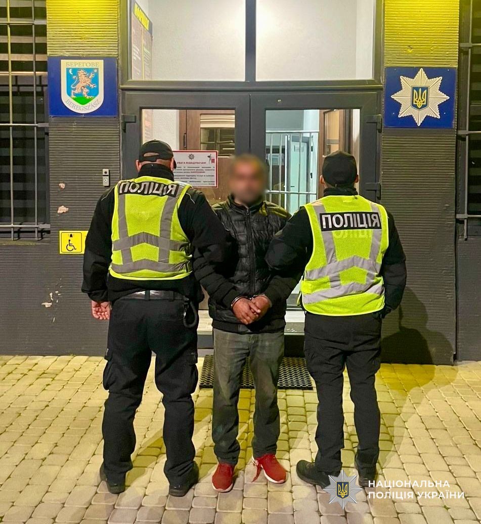 Поліцейські тримають затриманого за підозрою у вбивстві подружжя пенсіонерів